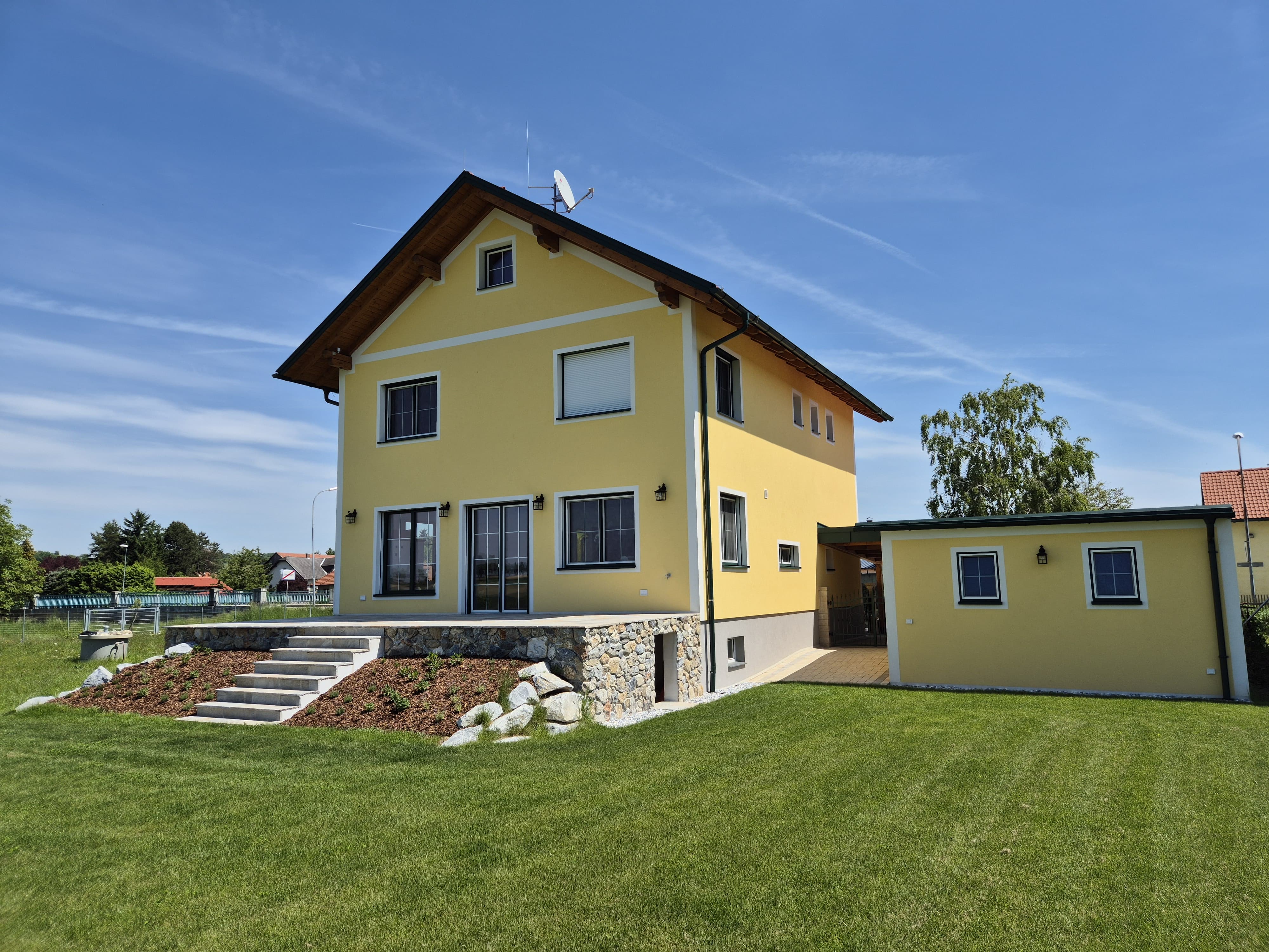 Südwestansicht des Hauses mit Terrasse und Nebengebäude